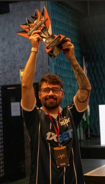 Jhonatan erguendo um troféu com a camisa do MIBR